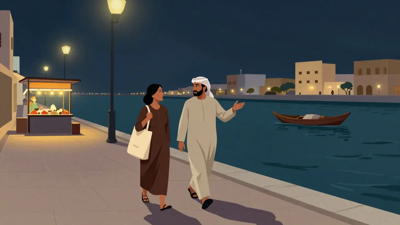 Two people walking along Dubai Creek at night, talking warmly under streetlights with traditional boats nearby.